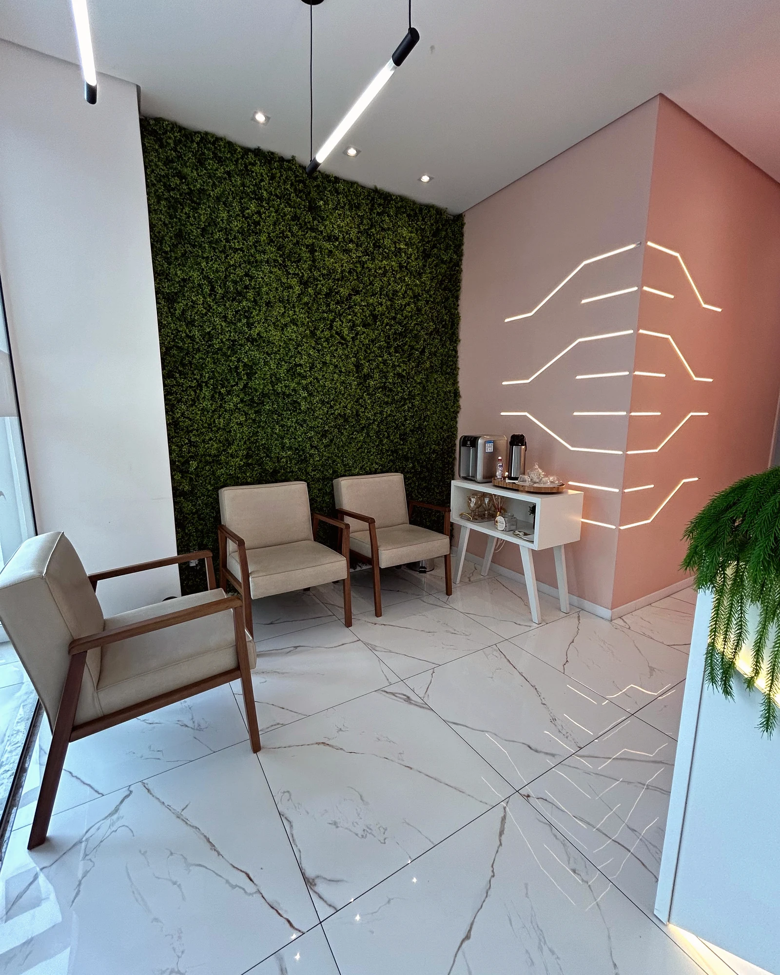 Área de espera real da Bestlaser com poltronas e parede verde.